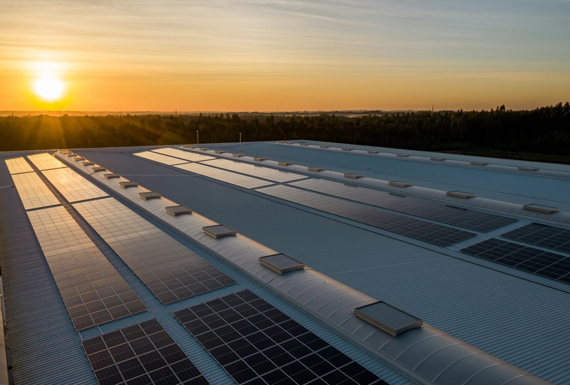 Rooftop solar array on a manufacturing facility at sunset
